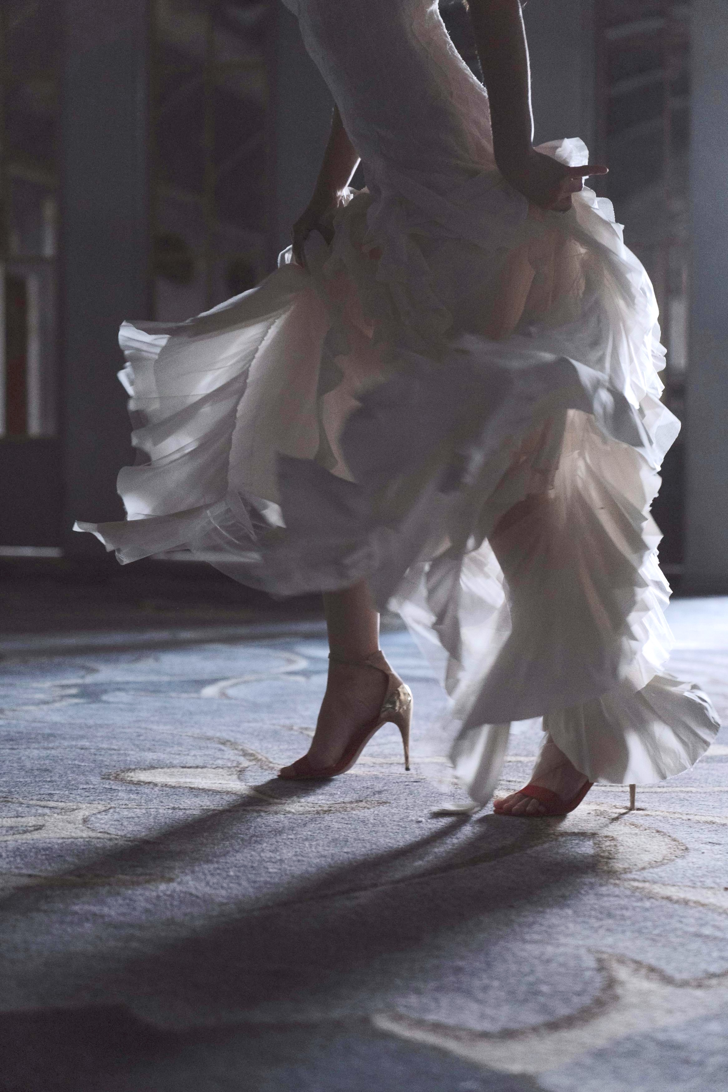 cropped image of a woman in a white dress in motion